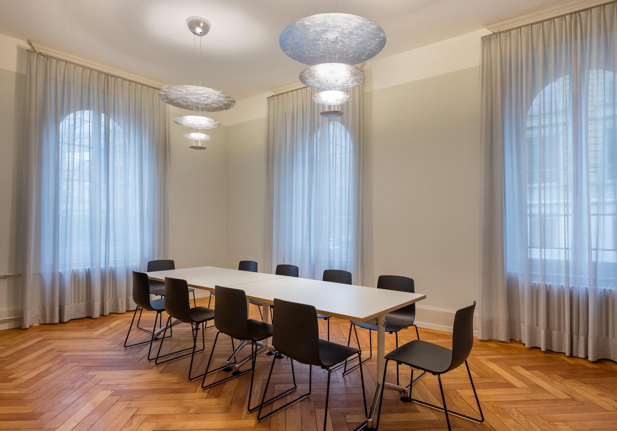 „Atmosphäre zwischen Tradition und Gegenwart“ – die Beleuchtung und textile Gestaltung verwandeln das historische Pfarrhaus in einen Ort, der sowohl feierliche Vorträge wie auch alltägliche Arbeiten in stimmungsvollem Licht erlebbar macht und den Geist des Hauses mit zeitgemässer Eleganz trägt.