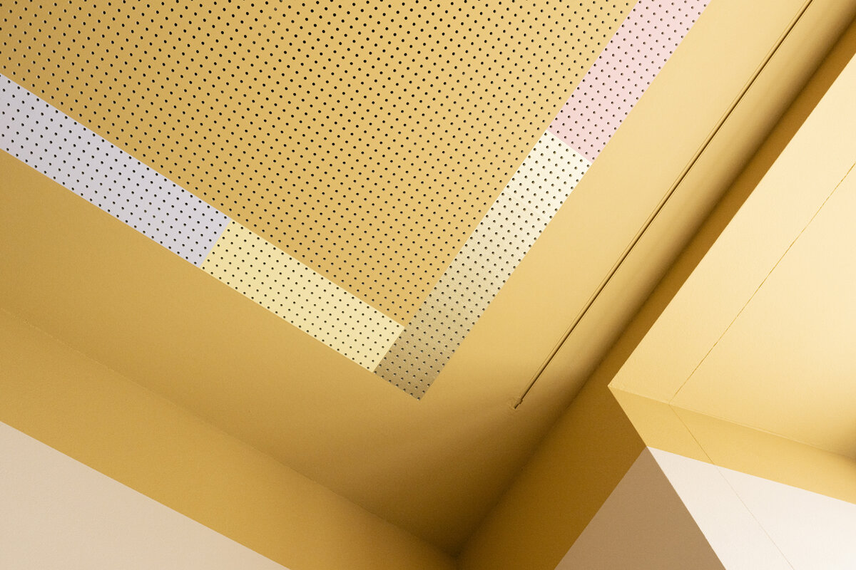 „Atmosphäre im Austausch“ – durch gezielte Farb- und Lichtakzente verwandeln sich überhöhte, nüchterne Räume in Orte, die Intimität, Kreativität und Dialog gleichermassen fördern.