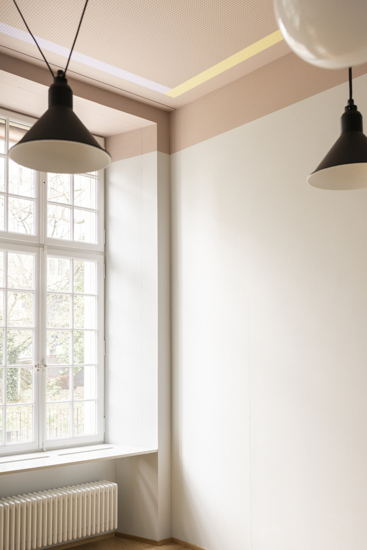 „Atmosphäre im Austausch“ – durch gezielte Farb- und Lichtakzente verwandeln sich überhöhte, nüchterne Räume in Orte, die Intimität, Kreativität und Dialog gleichermassen fördern.